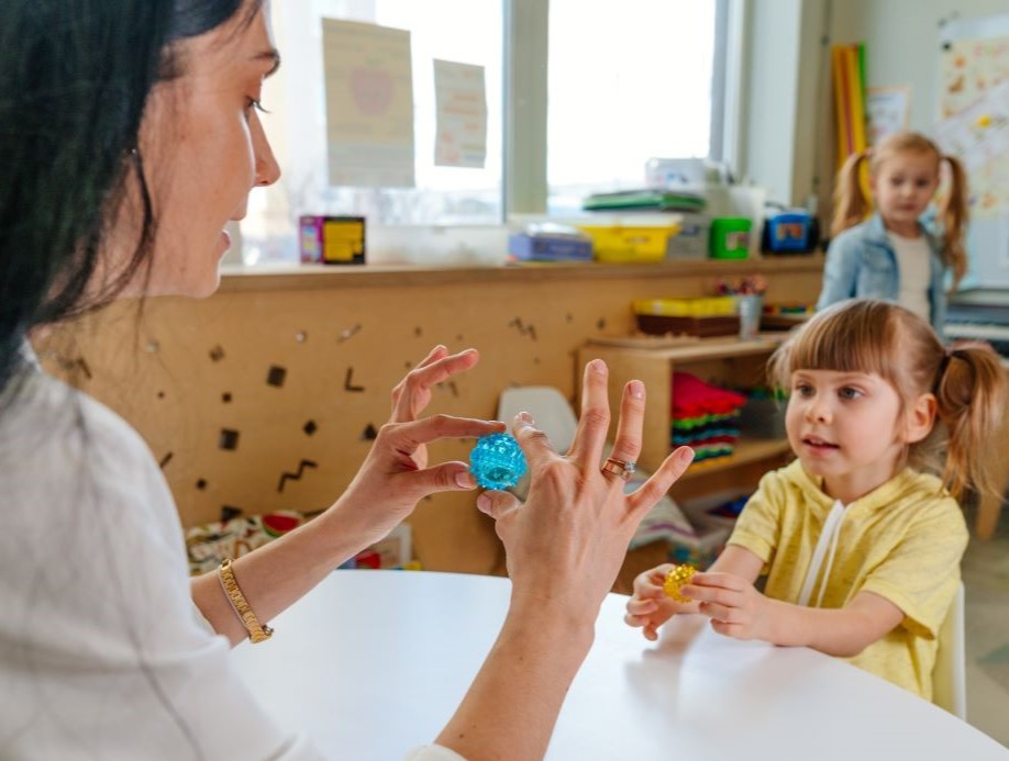 Educator helping child with fine motor skills